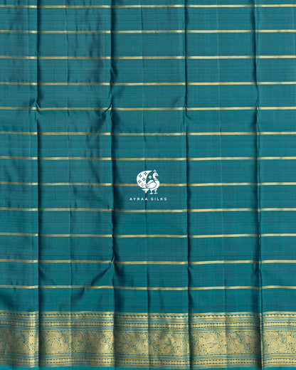 Close view of the running blouse in teal silk with gold zari stripes and a zari border