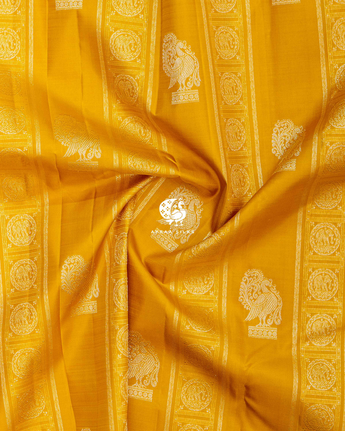 Close-up of the saree body, mustard silk with silver zari Annam buttas and elephant bands gathered in soft folds