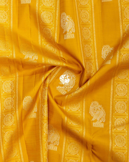 Close-up of the saree body, mustard silk with silver zari Annam buttas and elephant bands gathered in soft folds