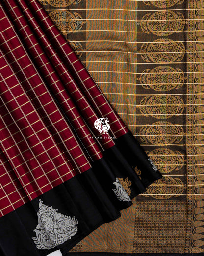 Maroon checked pleats with the black Mayil (peacock) border laid over the black zari medallion pallu