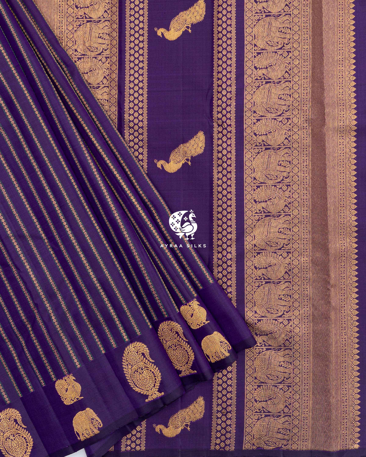 Pleats of Purple Butta Kanchipuram silk saree with manga and elephant zari buttas laid over its zari pallu with peacock buttas