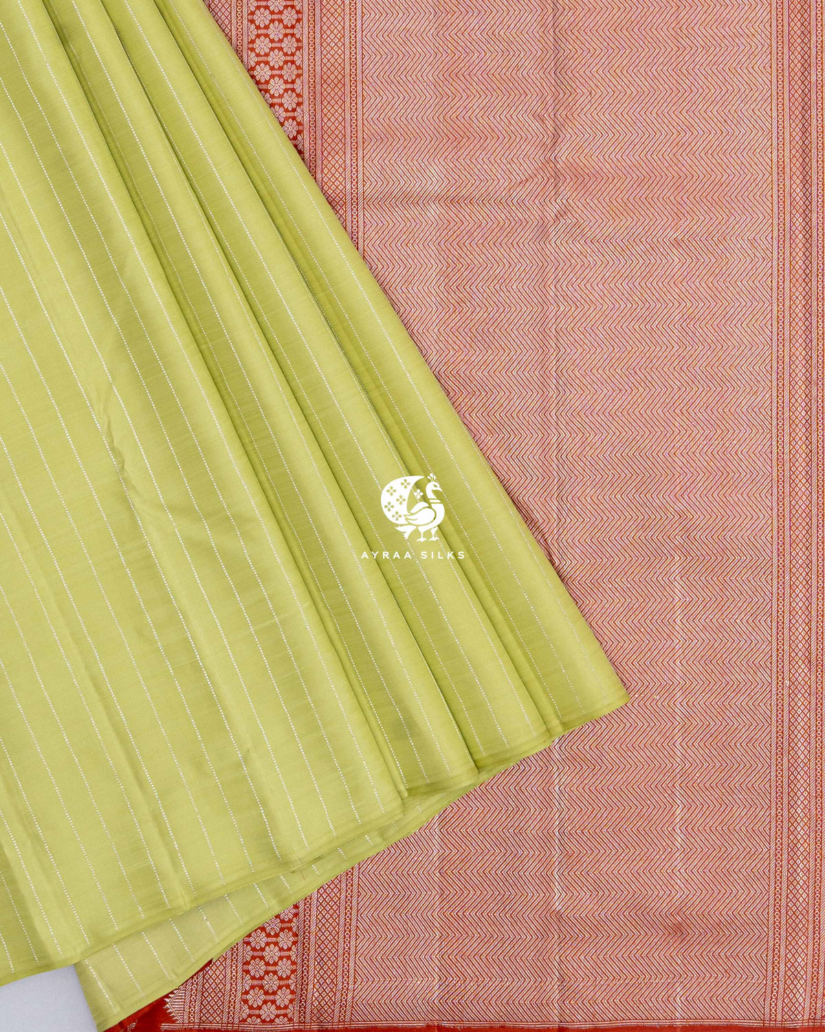 Pista green striped pleats laid over the rust orange zari pallu of the Kanchipuram silk saree