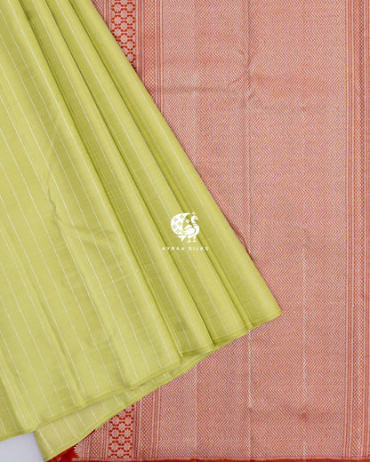 Pista green striped pleats laid over the rust orange zari pallu of the Kanchipuram silk saree