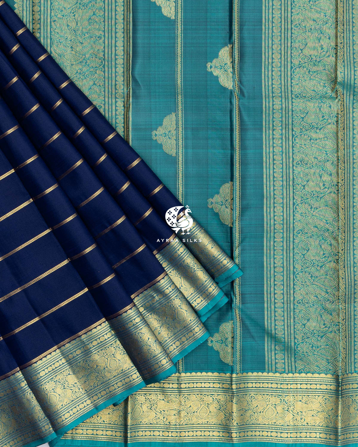 Pleats of Navy Blue Zari Vari Kanchipuram silk saree with teal zari border laid over its teal zari pallu