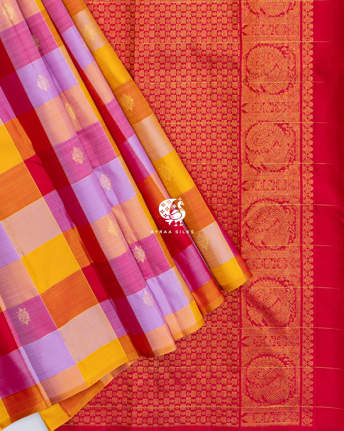 Multicolour checked pleats of the Kanchipuram silk saree laid over the red zari pallu with Mayil Chakra borders