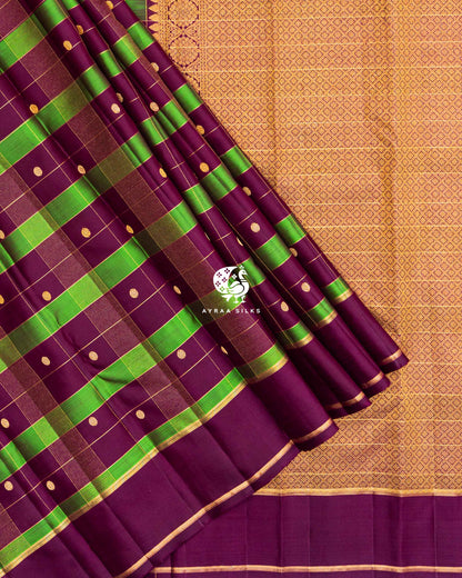 Close view of wine and green checked silk pleats with zari-lined wine border against the gold zari lattice pallu
