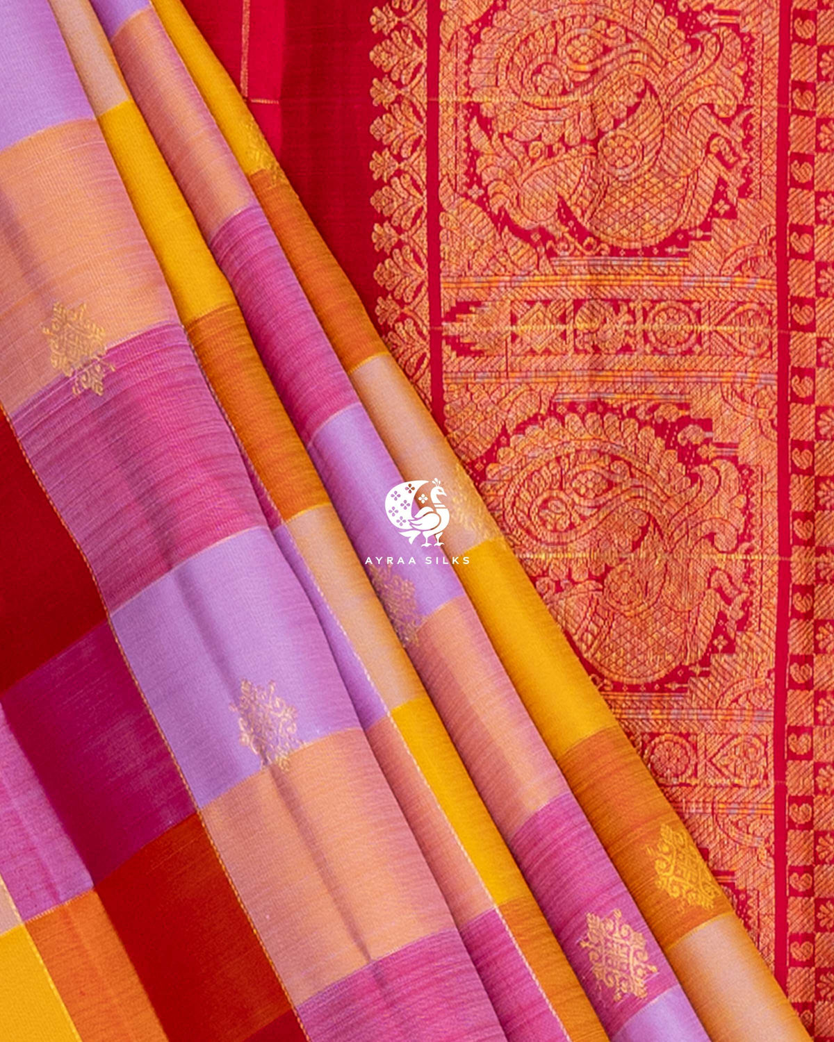 Close view of multicolour checked pleats beside the Mayil Chakra (peacock medallion) zari border of the red pallu
