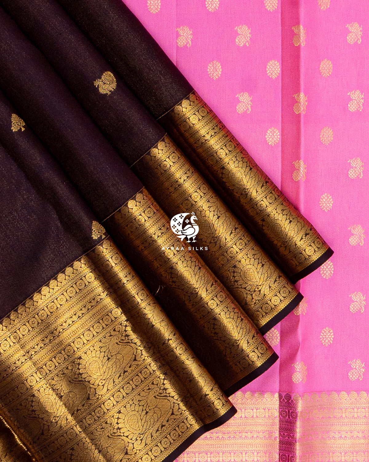Close view of the wide gold zari border with Mayil (peacock) motifs on coffee brown zari by zari silk against the bright pink pallu