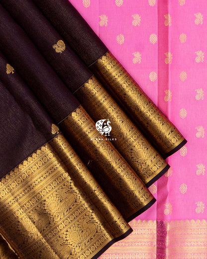 Close view of the wide gold zari border with Mayil (peacock) motifs on coffee brown zari by zari silk against the bright pink pallu