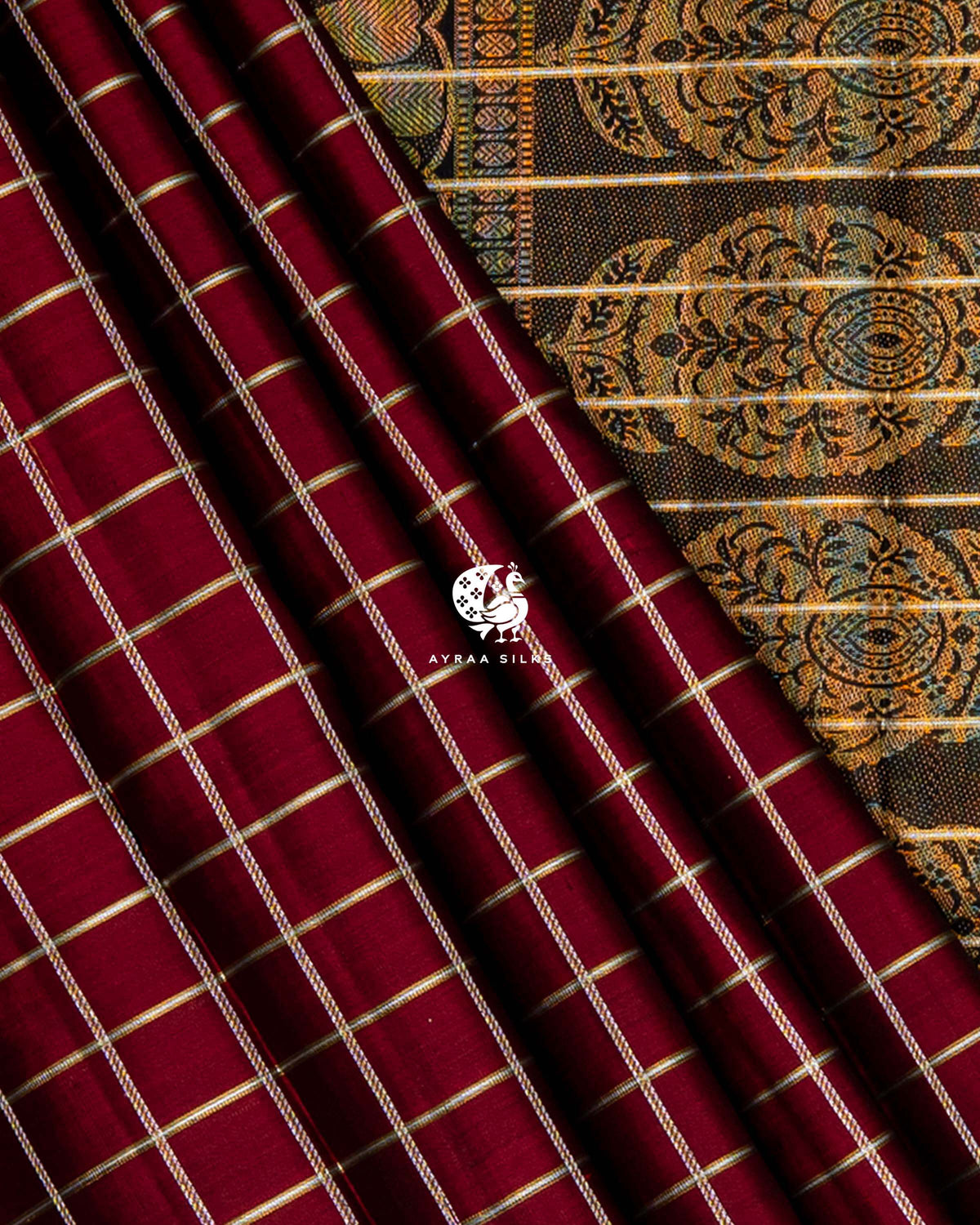 Maroon zari checked pleats against the multicolour zari medallions of the black pallu