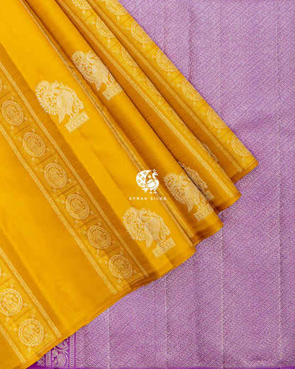 Mustard pleats with silver zari Annam buttas and elephant bands laid over the lavender diagonal zari pallu