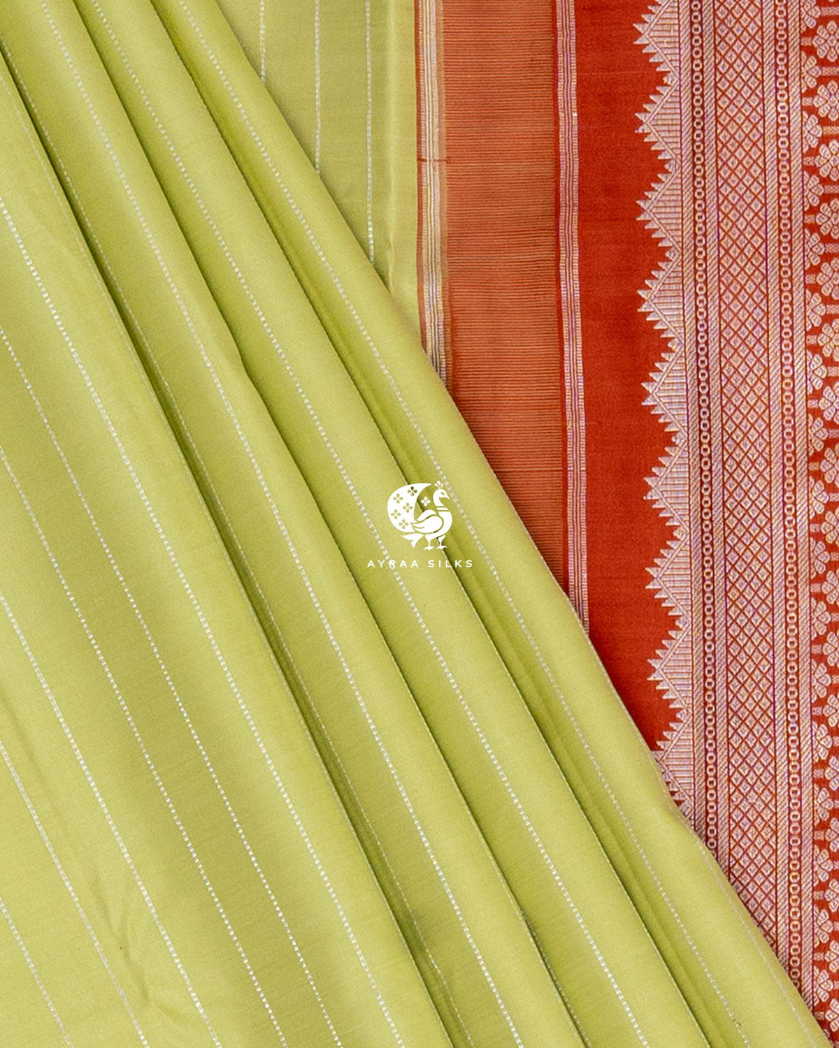 Pista green pleats beside the temple edge and floral zari side border of the rust orange pallu