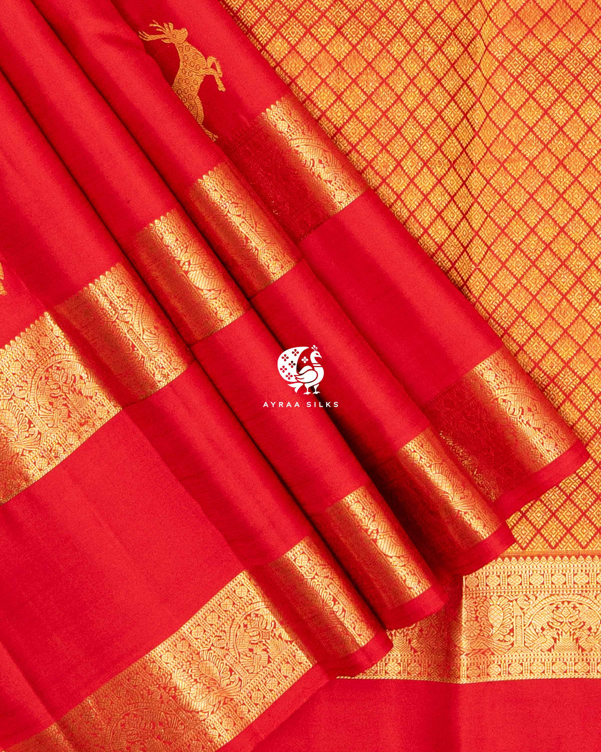 Close view of the double gold zari border with Mayil (peacock) and floral motifs on red pleats against the zari pallu