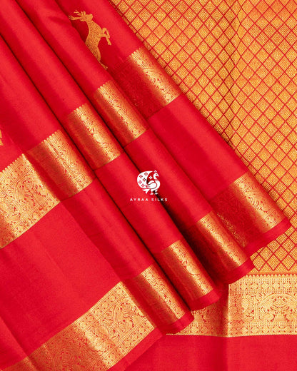 Close view of the double gold zari border with Mayil (peacock) and floral motifs on red pleats against the zari pallu