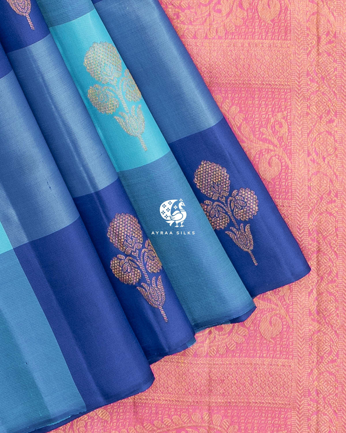 Close view of floral zari buttas on the blue checked pleats against the pink zari pallu
