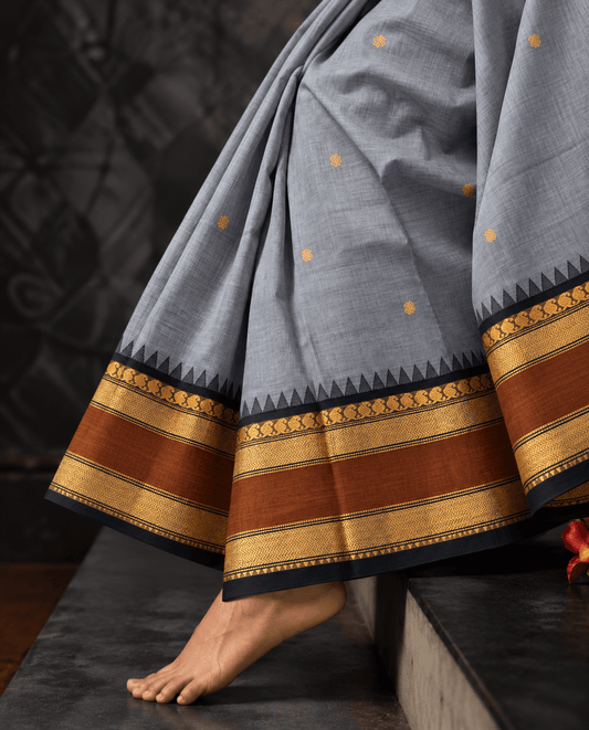 Grey Kanchi cotton saree draped, rust and black temple border with zari buttas — handwoven pure cotton by Ayraa Silks