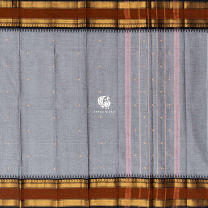 Grey Kanchi cotton saree laid flat, pallu with stripes and zari buttas, rust temple borders both sides