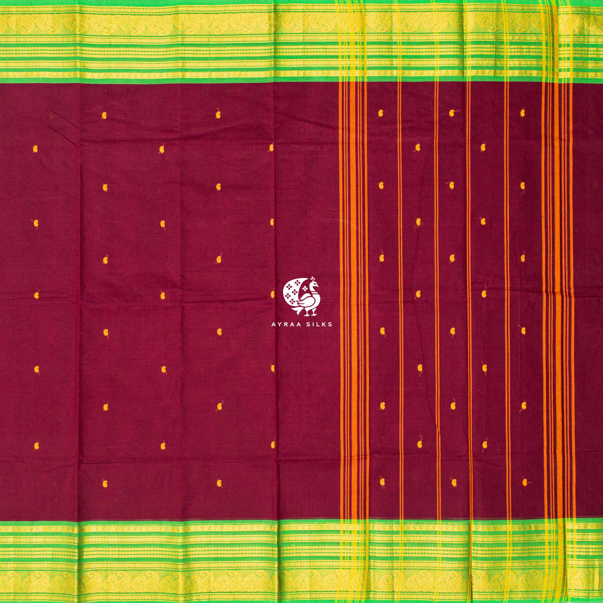 Maroon Kanchi cotton saree laid flat, pallu with mustard stripes and green zari borders on both sides